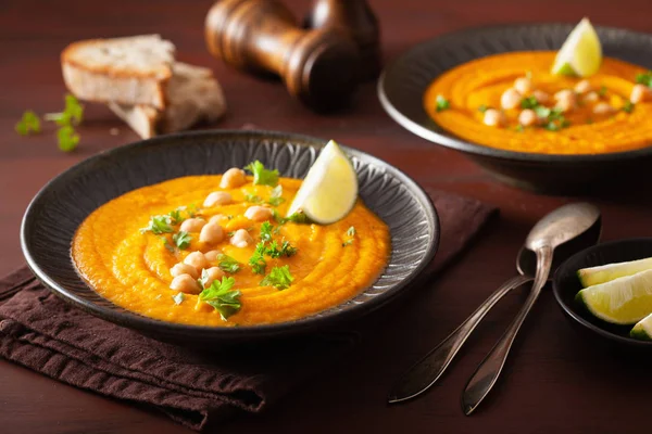 Sopa de grão de bico de cenoura cremosa no fundo rústico escuro — Fotografia de Stock