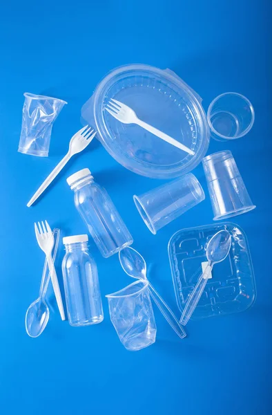 single use plastic bottles, cups, forks, spoons. concept of recy