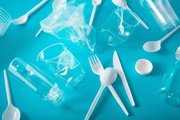 single use plastic bottles, cups, forks, spoons. concept of recy