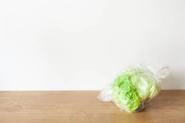 Айсберг салат овоч у поліетиленовому пакеті. одинарне використання пластикового пакета — стокове фото