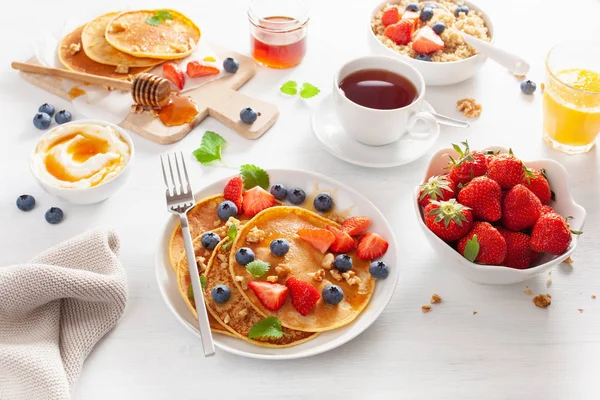 Pancake dengan madu blueberry strawberry dan kacang untuk sarapan — Stok Foto