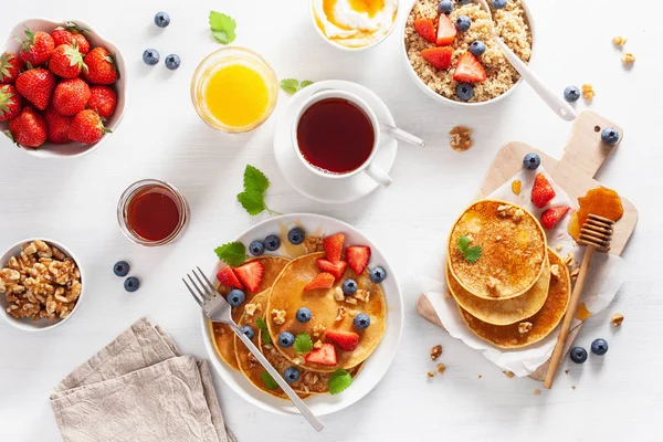 Pancake dengan madu blueberry strawberry dan kacang untuk sarapan — Stok Foto