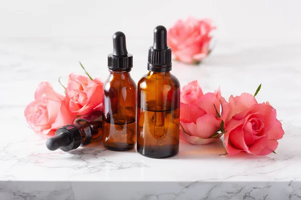 Aceites esenciales en botellas de flores de rosas. medicina alternativa aro — Foto de Stock