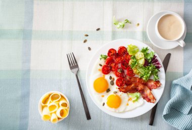 Sağlıklı keto diyeti kahvaltısı: yumurta, domates, salata yaprakları ve pastırma