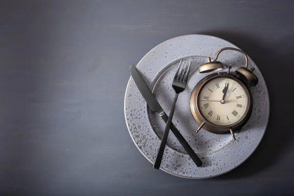 间歇性禁食的概念 产茶饮食 体重减轻 叉子和刀 盘上的闹钟 — 图库照片