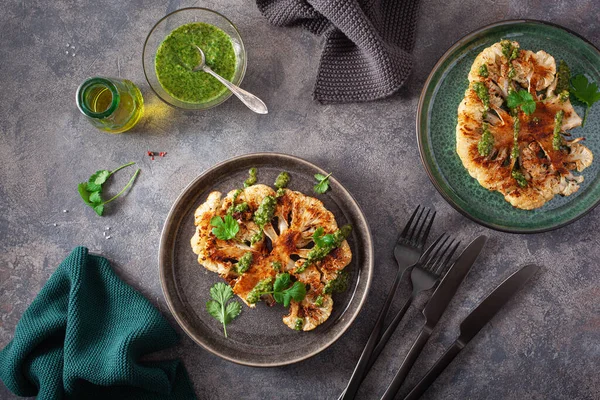 cauliflower steaks with herb sauce and spice. plant based meat substitute