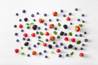 Beyaz arka planda çeşitli meyveler. yabanmersini, çilek, ahududu, böğürtlen