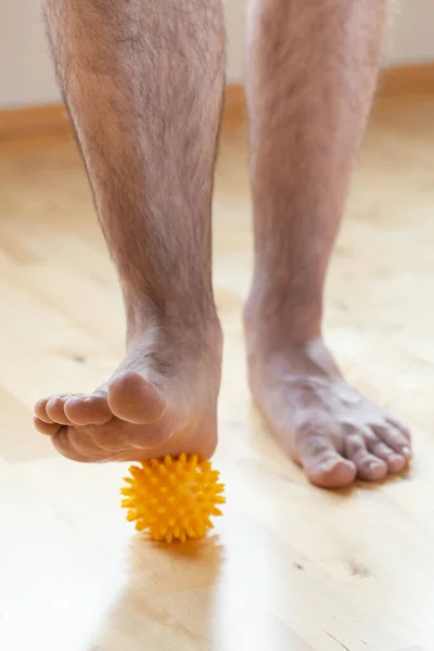 Mężczyzna Robi Płaskostopie Korekcji Gimnastyczne Ćwiczenia Pomocą Piłki Masażu Domu — Zdjęcie stockowe