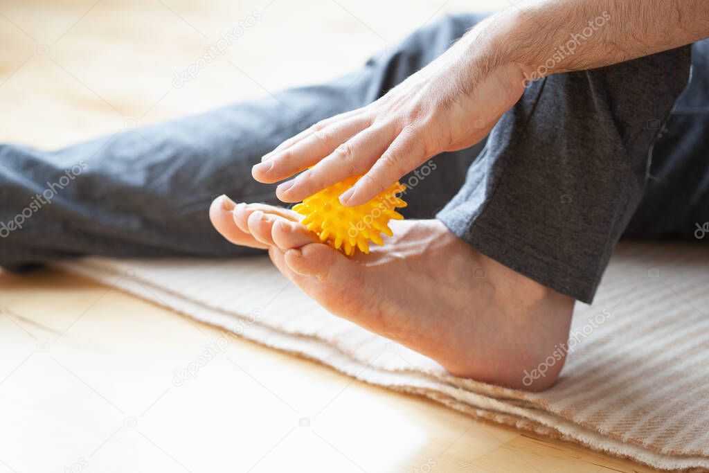 man doing flatfoot correction self massage at home