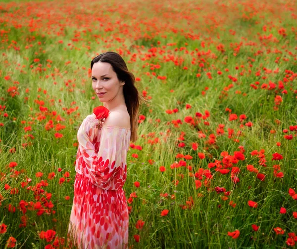 Beautiful young in the poppy field — Stock Photo, Image