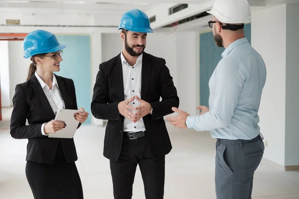 Ingenieros en sombreros tienen conversación en una fábrica — Foto de Stock