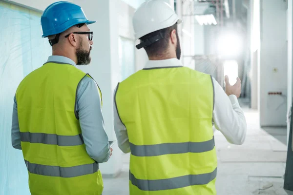 A hardhats mérnökei beszélgetés — Stock Fotó