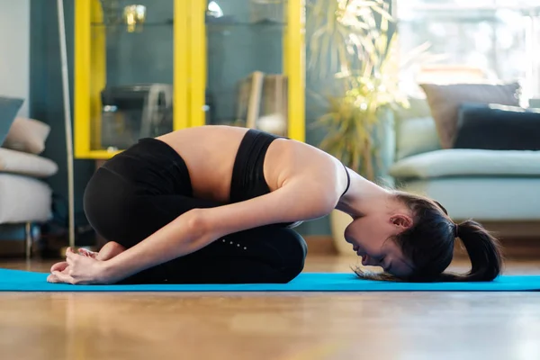 Vrouw die thuis yoga beoefent — Stockfoto