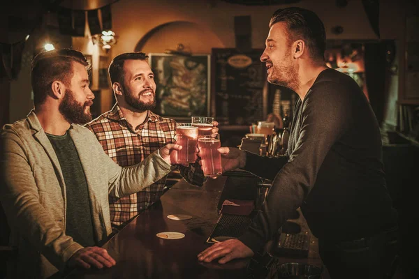 Old friends having fun and drinking draft beer at bar counter in pub. — Stock Photo, Image