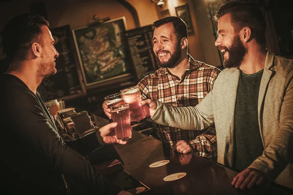 Viejos amigos divirtiéndose y bebiendo cerveza de barril en el bar . — Foto de Stock