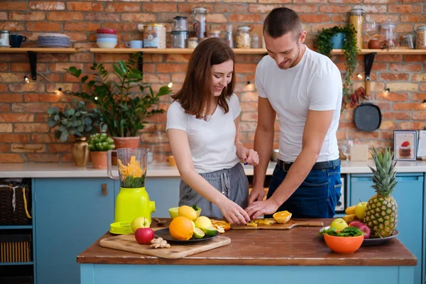 Jovem casal fazendo smoothie na cozinha — Fotografia de Stock