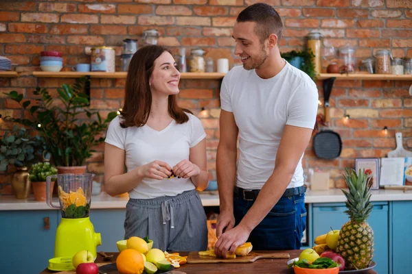 Ungt par att göra smoothie i köket — Stockfoto