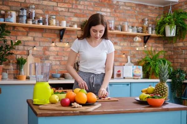 Jonge vrouw smoothie maken in de keuken — Stockfoto