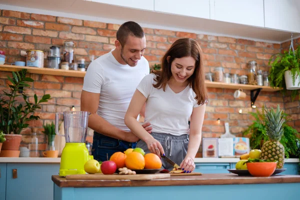 Jovem casal fazendo smoothie na cozinha — Fotografia de Stock