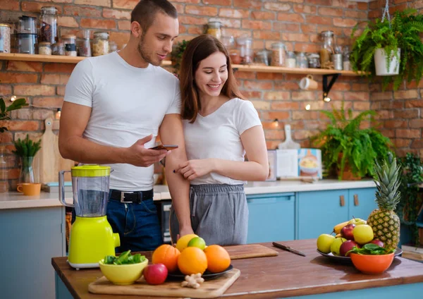 Ungt par att göra smoothie i köket — Stockfoto