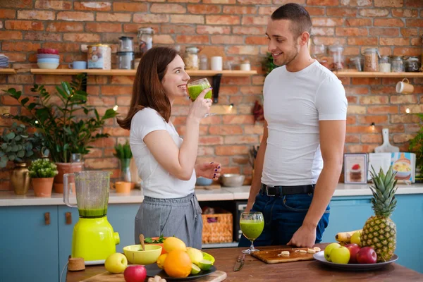 Молода пара робить гладкість на кухні — стокове фото