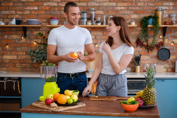 Jovem casal fazendo smoothie na cozinha — Fotografia de Stock