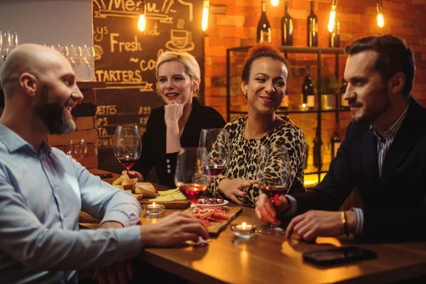 Grupo de amigos divirtiéndose hablando detrás del mostrador de la barra en un café — Foto de Stock