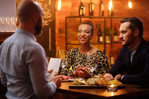 Casal conversando com barman atrás do balcão de bar em um café — Fotografia de Stock