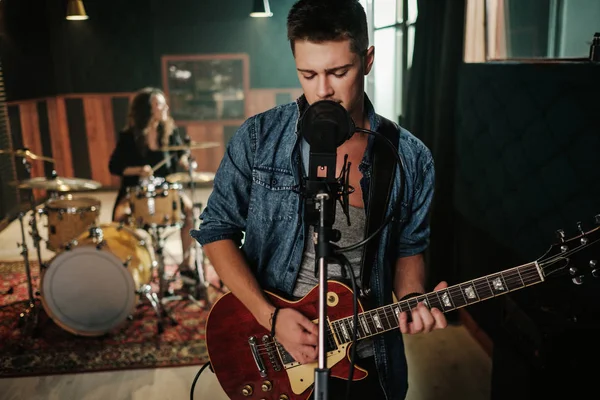 Music band having rehearsal in a studio