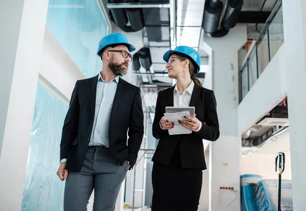 Ingénieurs en hardhats avoir une conversation — Photo