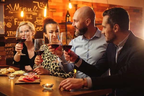 Группа друзей весело разговаривает за барной стойкой в кафе — стоковое фото