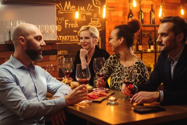 Groep vrienden plezier praten achter toog in een café — Stockfoto