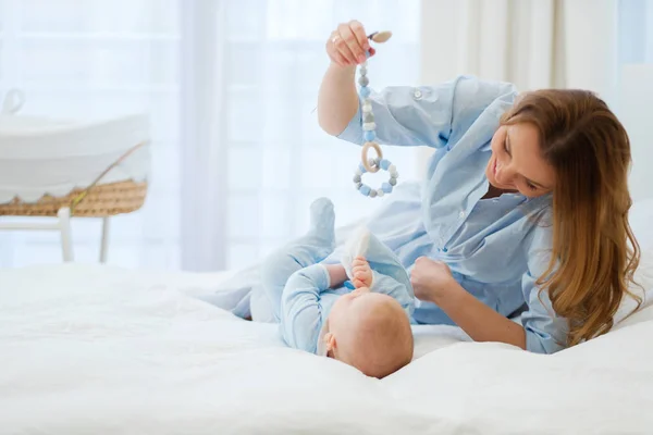 Feliz madre de mediana edad con su hijo en una cama —  Fotos de Stock