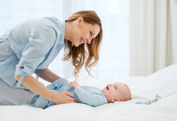 Feliz madre de mediana edad con su hijo en una cama — Foto de Stock