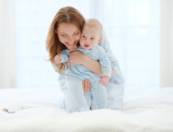 Mãe de meia-idade feliz com seu filho em uma cama — Fotografia de Stock