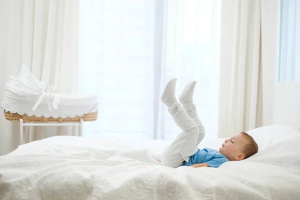 Jongetje spelen in een bed — Stockfoto