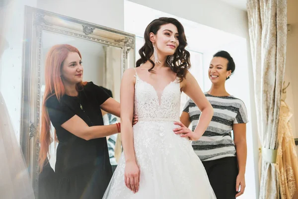 Красивая невеста выбирает свадебное платье в свадебном салоне — стоковое фото