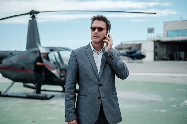 Adamı Özel Helikopterin Yanında Cep Telefonuyla Konuşuyor — Stok fotoğraf