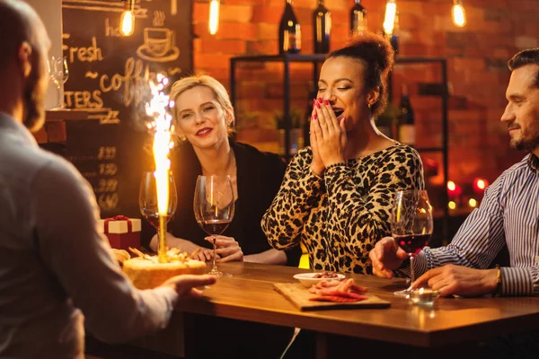 Group of friends celebrating birthday in a cafe behind bar counter — Stock Photo, Image