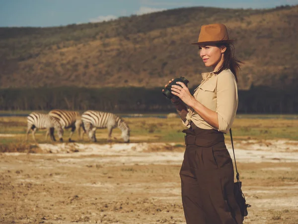 Hermosa mujer con prismáticos en savanna en Kenia — Foto de Stock