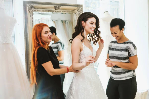 Beautifu novia elegir vestido de novia en un salón de bodas —  Fotos de Stock