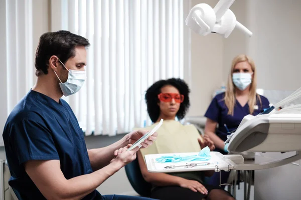 Ο οδοντίατρος και ο βοηθός που εργάζεται σε ιδιωτικό ιατρείο — Φωτογραφία Αρχείου
