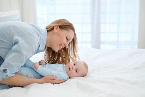Felice madre di mezza età con il suo bambino in un letto — Foto Stock