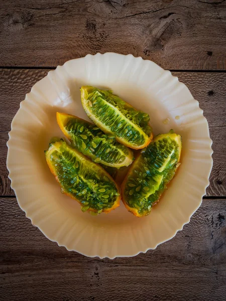 Fruta tropical kiwano o melón con cuernos en un plato blanco —  Fotos de Stock