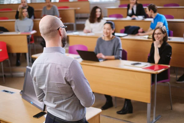 Chargé de cours et groupe multinational d'étudiants dans un auditorium — Photo