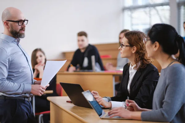 Lecturer and multinational group of students in an auditorium — Stock Photo, Image