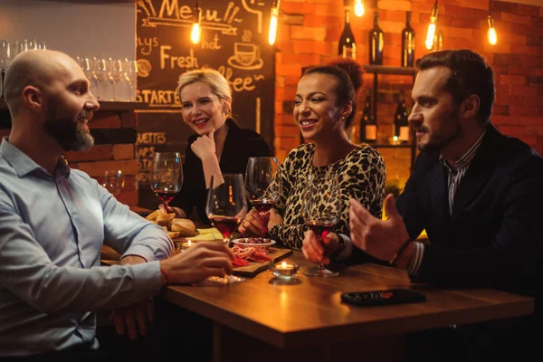 Grupo de amigos se divertindo conversando atrás do balcão de bar em um café — Fotografia de Stock