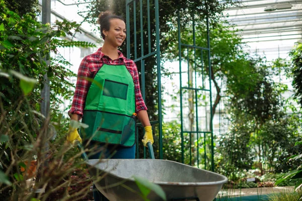 Donna nera con carriola in un giardino botanico — Foto Stock