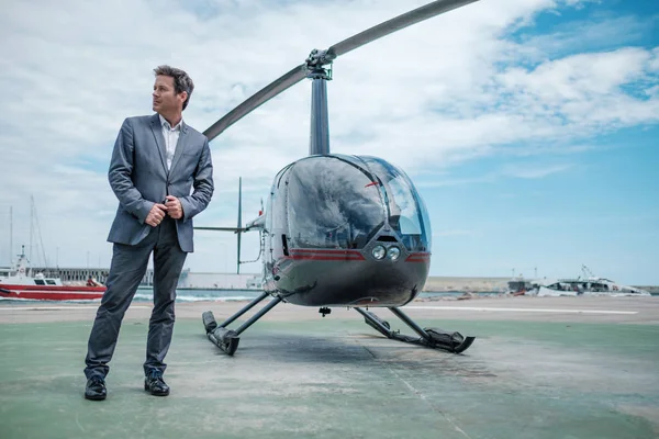 Biznesmen stojący w pobliżu prywatnego helikoptera — Zdjęcie stockowe