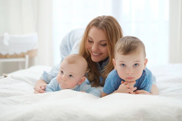 Szczęśliwy średniej wieku matki z jej dzieci w łóżku — Zdjęcie stockowe